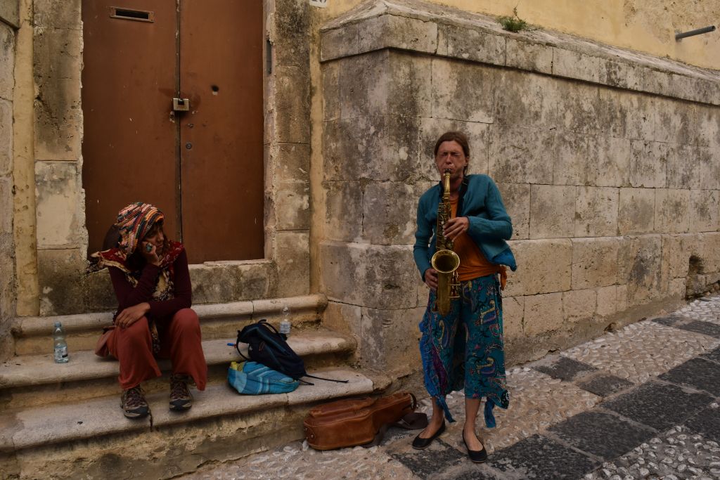 L'amarezza , la spensieratezza e la stanchezza di due artiste di strada in uno dei vicoli di Noto